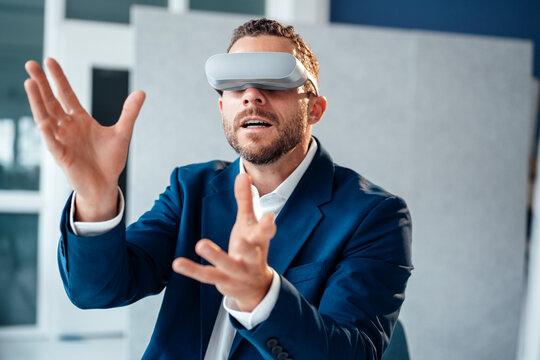 Businessman gesturing wearing virtual reality headset in office