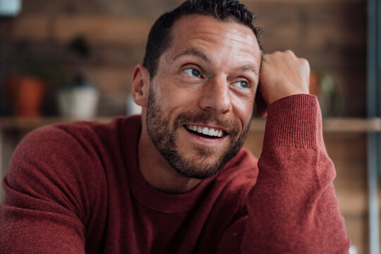 Smiling mature man with head in hand