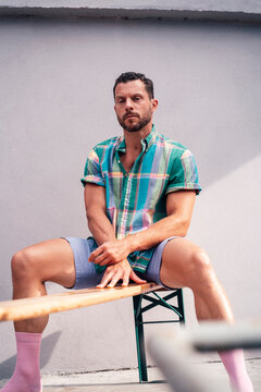 Man sitting on bench in front of wall