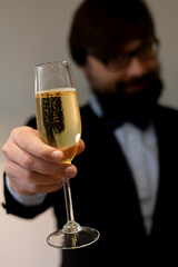 Close-up businessman man with happy face hand holding a glass of champagne or sparkling wine