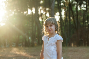 Adorable little child girl having fun on a sunny summer day outdoor in sunlight