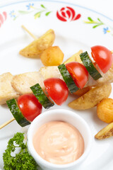 chicken kebab with sauce and vegetables