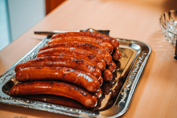 Gebratene Bratwürste auf einem silbernen Tablett