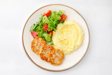 Mashed potatoes with chicken and salad on a white background