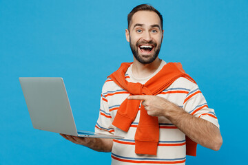 Young amazed fun freelancer happy satisfied copywriter man 20s wearing orange striped t-shirt hold...