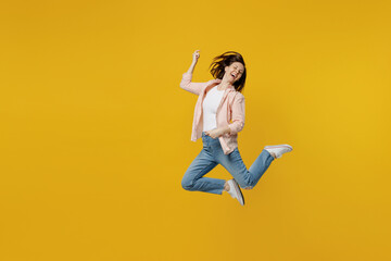 Fototapeta na wymiar Full body young happy excited singer musician woman she 30s in striped shirt white t-shirt jump high play guitar gesture isolated on plain yellow background studio portrait. People lifestyle concept