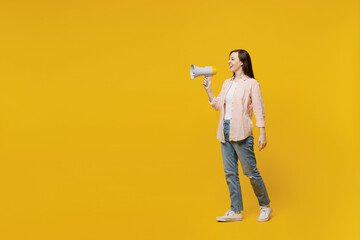 Fototapeta na wymiar Full body young happy smiling woman she 30s wears striped shirt white t-shirt hold scream in megaphone announces discounts sale Hurry up walk go isolated on plain yellow background studio portrait