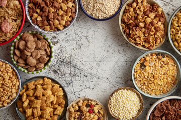 Assortment of different kinds cereals placed in ceramic bowls on table