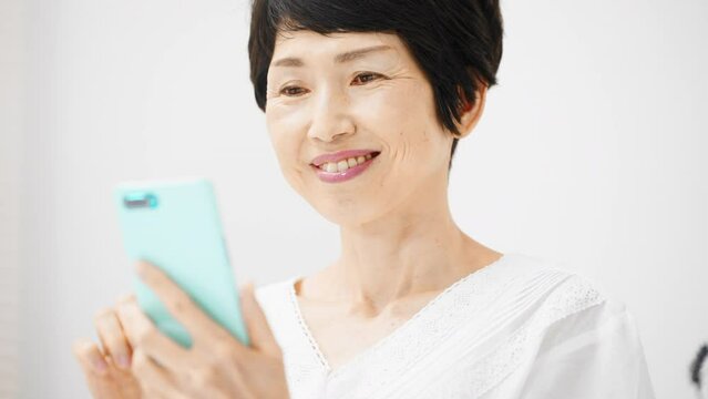 スマートフォンを操作するミドル女性