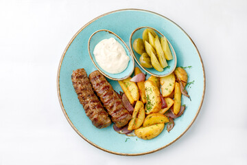 French fries with sausage and sauce on a white background