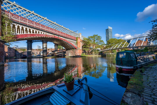 Railway, footbridge and canal boat moored at Castlefield, Manchester, Lancashire, England
