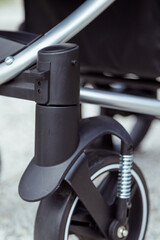 Locking button on the front wheels in a baby stroller.