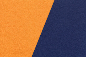 Fototapeta premium Texture of craft orange and navy blue paper background, half two colors, macro. Structure of craft indigo cardboard.
