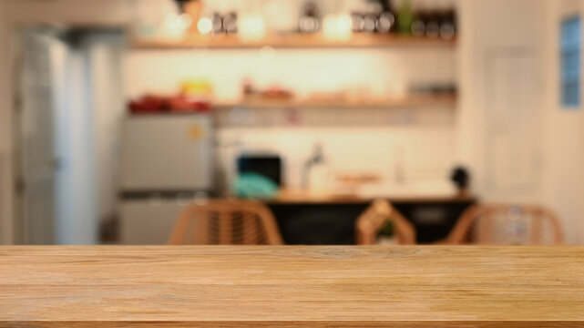 Wooden table against blurred modern kitchen in background. Copy space for display or montage your products