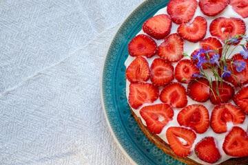 Cake with strawberries and cream on blue plate. Summer Strawberry and Cream sponge Layer Cake on...