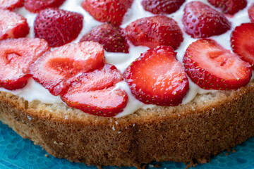 Cake with strawberries and cream on blue plate. Summer Strawberry and Cream sponge Layer Cake on white table cloth background. Top view, copy space. Midsummer food dessert