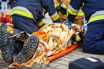 Rescuers provide first aid to the victim during a car accident. Person injured in the accident is...