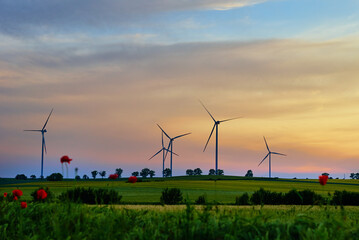 Fototapeta na wymiar Windmill turbine generator against beautiful sunset sky in countryside area, Concept of clean, renewable, sustainable, alternative energy