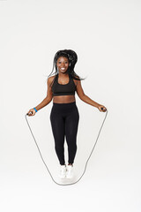 Black young sportswoman working out with jumping rope