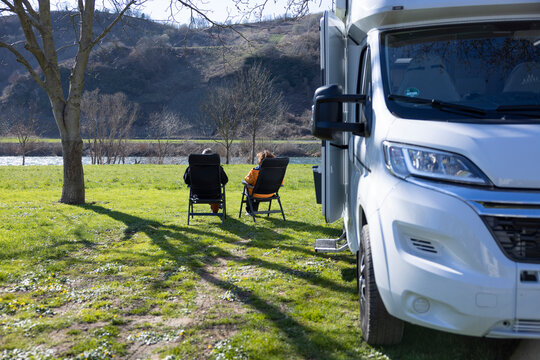 Camper sitzen auf einem Campingplatz neben ihrem Wohnmobil