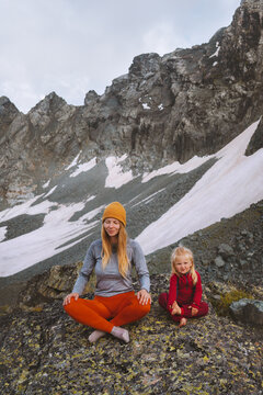 Family mother and daughter outdoor practicing yoga in mountains healthy lifestyle vacations parent and child training together harmony with nature meditation