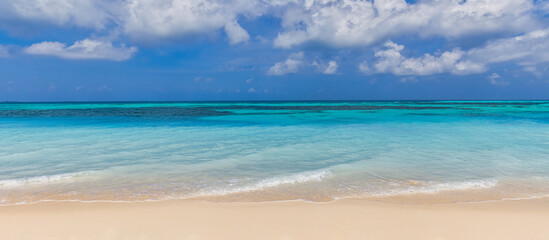 Closeup of sand on beach and blue summer sky. Panoramic beach landscape. Empty tropical beach and seascape. Blue sky, soft sand, calmness, tranquil relaxing sunlight, summer mood. Travel vacation
