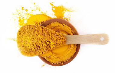 Turmeric powder (Curcuma) in wooden spoon and clay pot isolated on white, top view