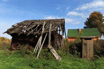 Abandoned, useless wooden house or barn. Falling apart structure. Rickety wooden construction