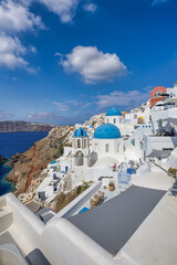 View of Oia town in Santorini island in Greece. Famous Greek landscape, blue domes over white architecture. Luxury summer holiday destination, romantic travel scenic. Beautiful cityscape and blue sea