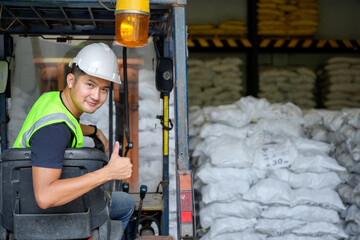 Asian male worker work in an industrial plant A young Asian man drives a forklift in an industrial...