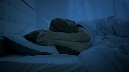 Depressed woman feels emptiness lying in bed at late night