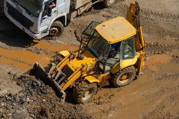 Wheel loader clears the site during excavation work on a construction site.Excavator with a front...