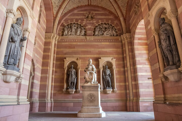 Fototapeta na wymiar Lovely view of the statue of King Rudolf I of Habsburg in the narthex of the famous Speyer Cathedral in Rhineland-Palatinate, Germany. The monument shows the ruler sitting on a throne with his crown.