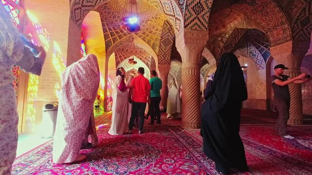 Shiraz, Iran - 8th june, 2022: Nasir Al-mulk crowded mosque interior time lapse with tourist walk explore and take photo of beautiful interior details
