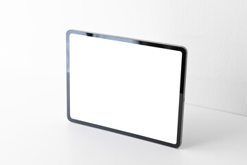 Front view of portable digital tablet computer with blank screen on white desk and background. Empty frame of tablet PC gadget for presentation and mockup with copy space.