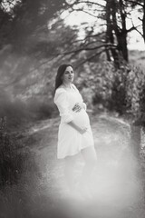 Young happy pregnant woman relaxing and enjoying life in nature. Outdoor shot. Copyspace