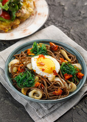 Plate with asian food - buckweet noodle with egg, mashrooms and vegetables