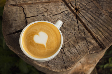 A cup of cappuccino with a heart on a stump. View from above