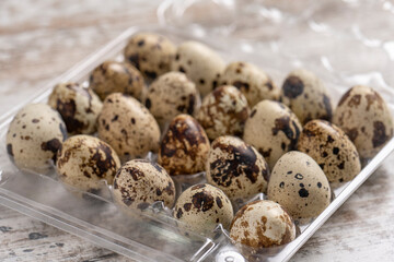 Obraz premium Quail eggs in plastic containers on a wooden table