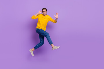 Fototapeta na wymiar Full length profile side image of overjoyed carefree man running go on vacation isolated on violet color background