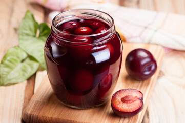 Canned plums in a glass jar closeup