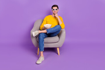 Full size photo of young positive peaceful man watch 3d film enjoying yummy snack isolated on violet color background