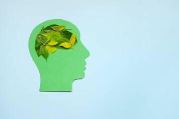 Environment conservation ideas, awareness, initiative, innovation and think solution for environmental problem concept. Human head profile cutout with fresh leaves as brain.