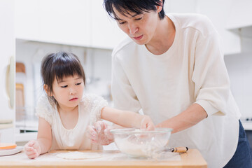 娘と生地をこねるパパ