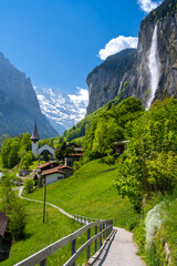 amazing alpine landscape in Lauterbrunnen village with church and waterfall in Switzerland - 512071967