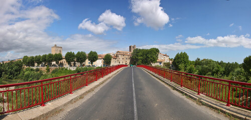 Skyline of the old town of Fabrezan with a road bridge over Orbieu river in Aude, Occitanie region in France