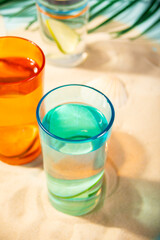 Summer non alcoholic cocktails in colorful glasses on beach with white sand. Summer sea ocean vacation and travel concept