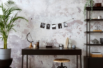Concrete interior of home office with black desk,  black and white image, office accessories and plants. Rack with personal accessories. Home decor. Template.
