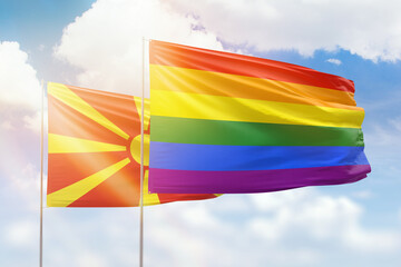 Sunny blue sky and flags of lgbt and north macedonia