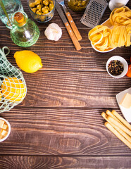 composition of healthy food ingredients for cooking italian pasta. Spaghetti, parmesan, basil, lemon on wooden kitchen rustic table. Top view. Copy space.